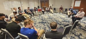 Brothers meeting with an alumni mentor discussing finances.